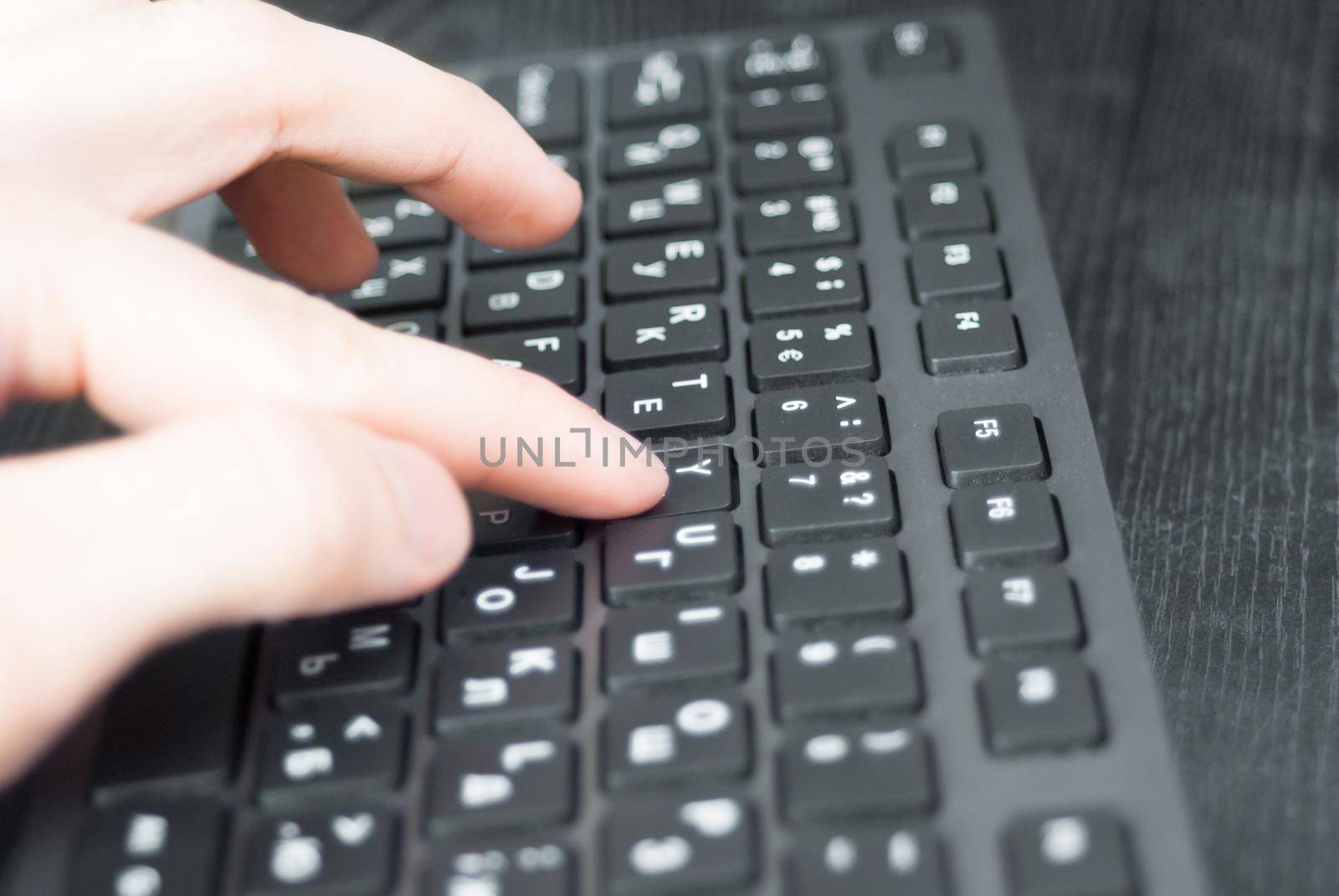 Pressing the keyboard closeup. Black keyboard on the desk