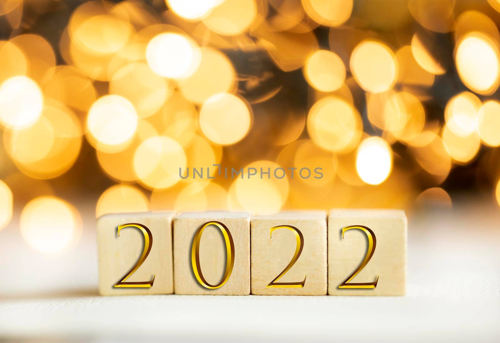 The year 2022 written on wooden cubes in gold luxury letters with shiny bokeh background, New Year celebration concept glitter by Annebel146