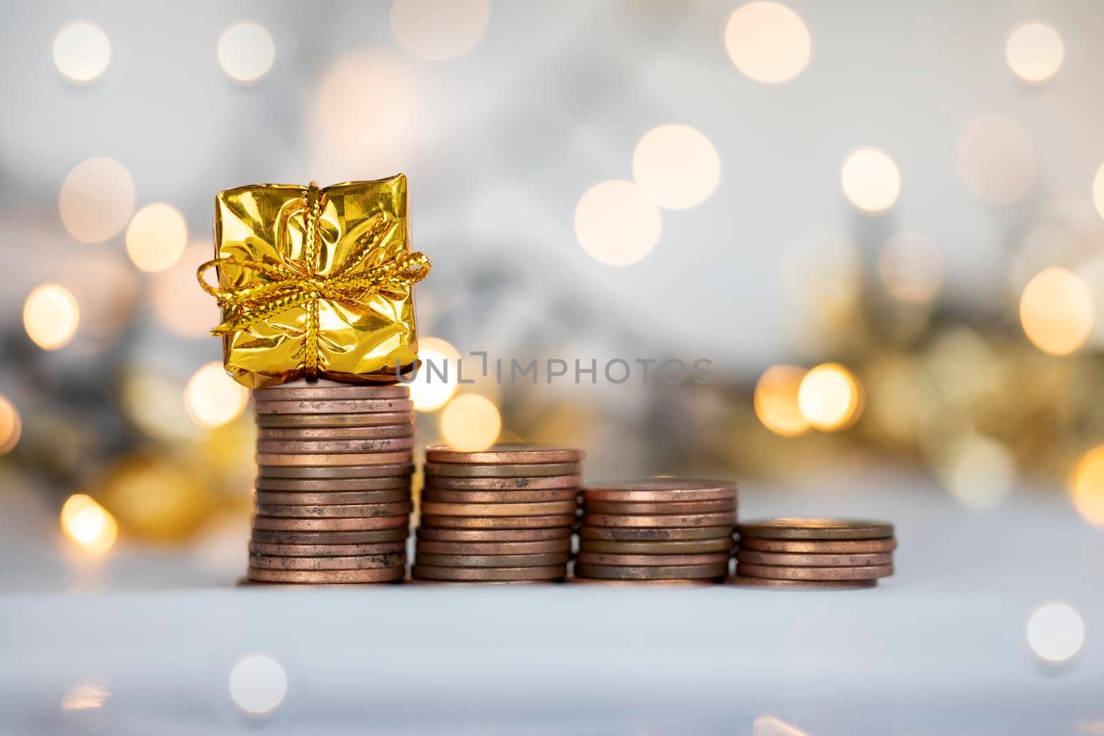 Coin climbing stairs with Christmas Holiday present, sparkling and shiny background, Finance,saving concept stacks of coins copy space