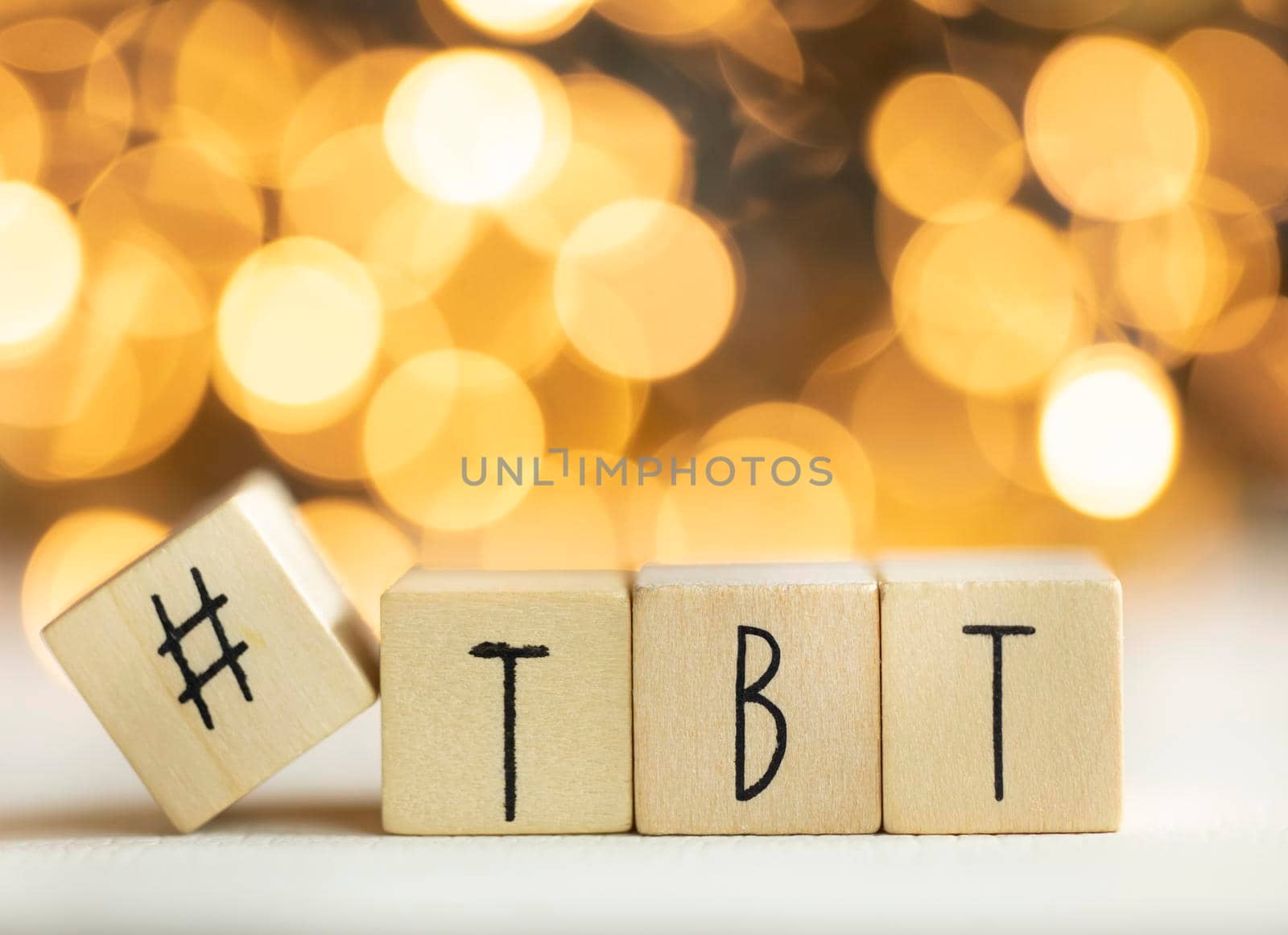 Hashtag TBT throwback Thursday written with wooden cubes with shiny bokeh background, social media concept colorful