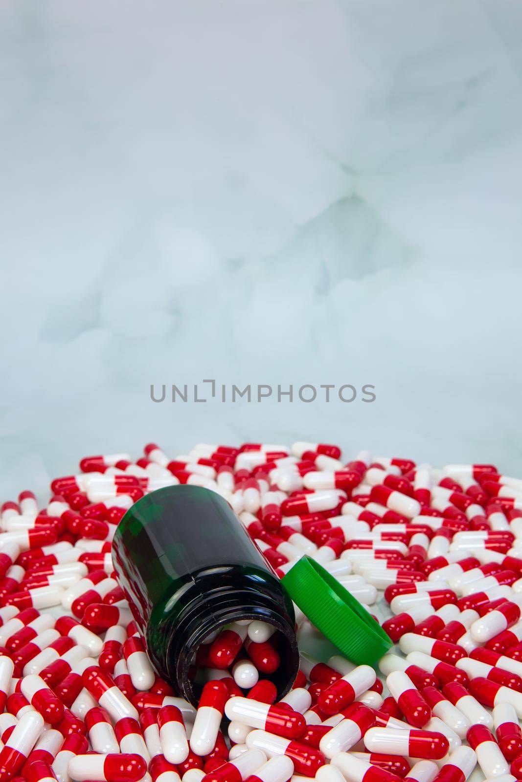 Bottle with red and white capsule on white background, Vitamin,drugs or pharmaceutical medication background, Health, medical and business concept copy space