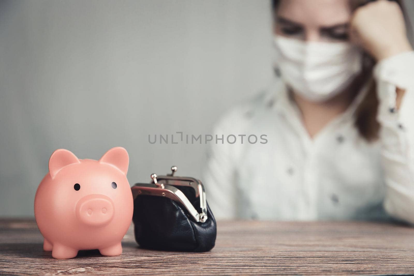 Young Female business woman with pink piggy bank for savings and wearing safety mask for Covid-19, depressed,financial,business,lockdown concept background debts