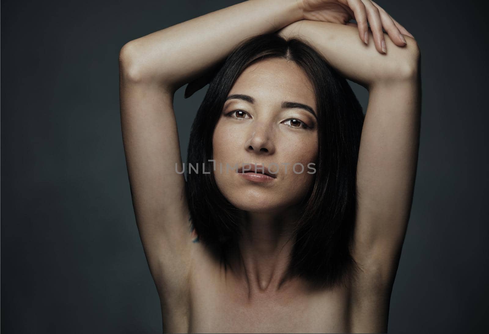 Portrait of attractive mixed race woman with beauty makeup and hairstyle on dark background