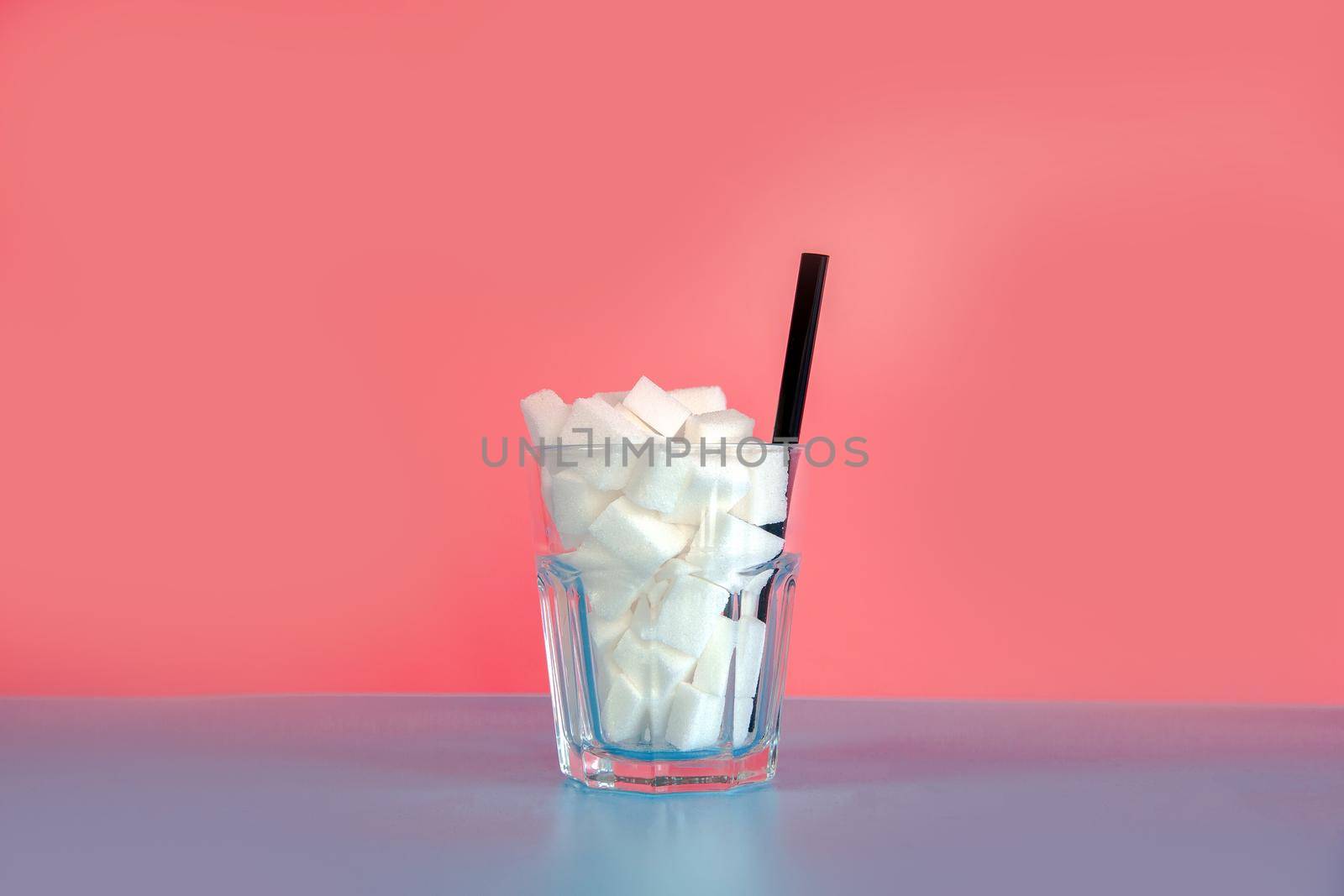 Glass full with sugar cubes with straw on pastel pink and blue background with copy space, retro design, Sweets,candy,soda,unhealthy eating concept. modern design by Annebel146