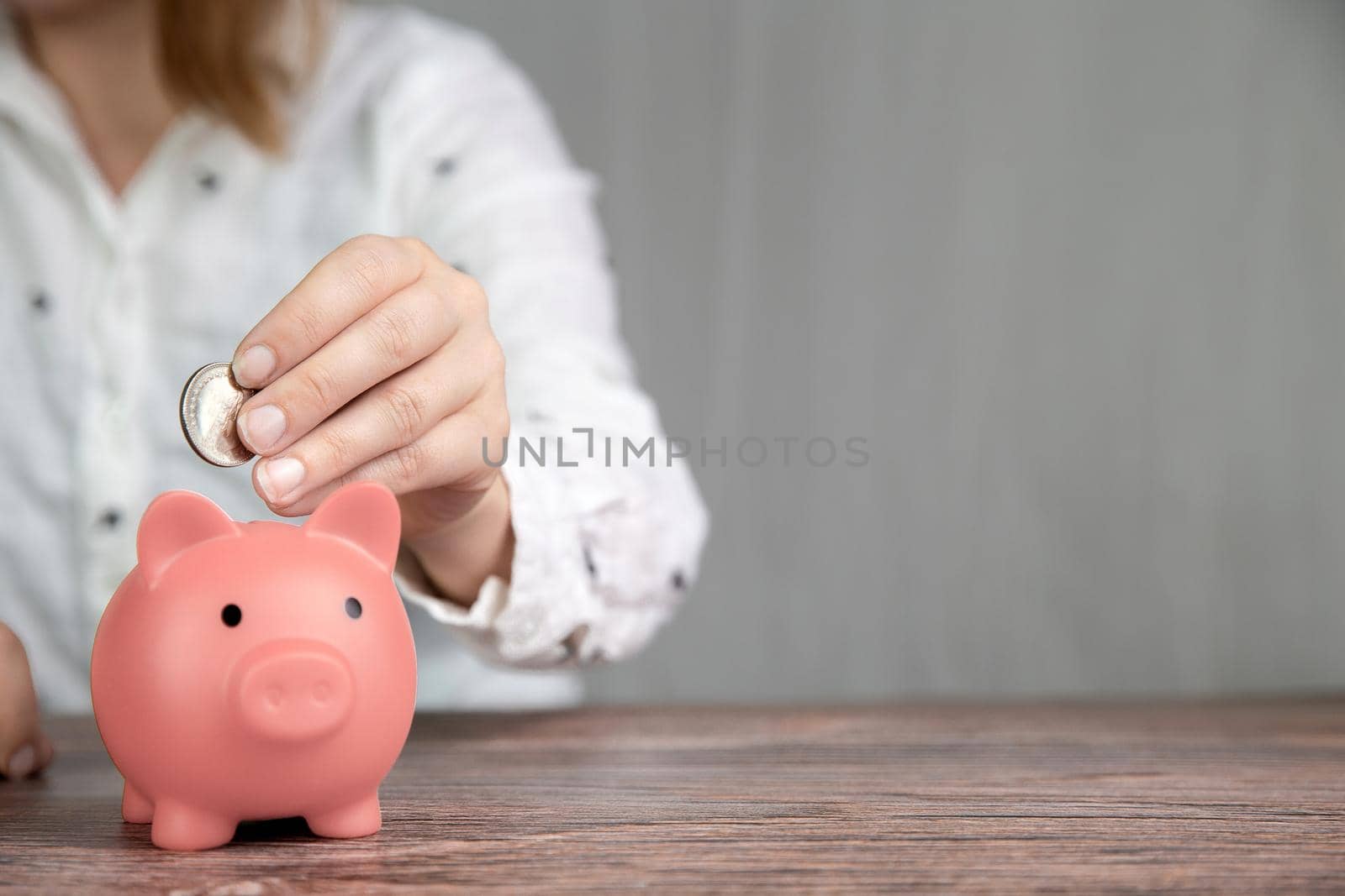 Piggy bank saving currency, person putting coin in for saving money, business, financial, savings and tax concept with copy space space for text