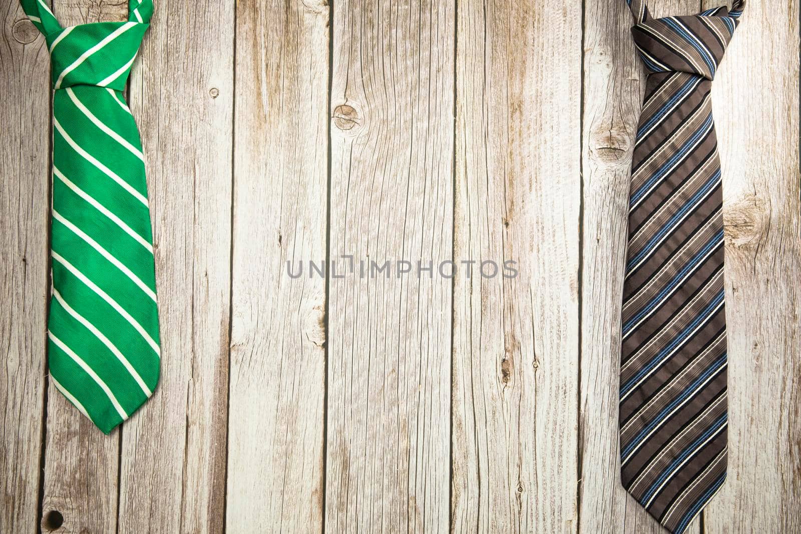 Colorful green and brown necktie on wooden background texture, National men's Day, Father Day design with copy space Space for text