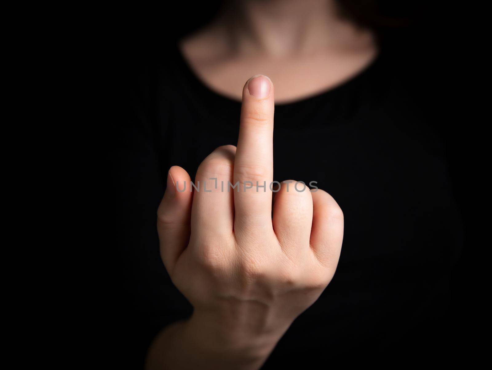 Hand flipping the finger,middle finger up,hand gesturing on dark background, agression,angry,hand, fuck off symbol concept by Annebel146