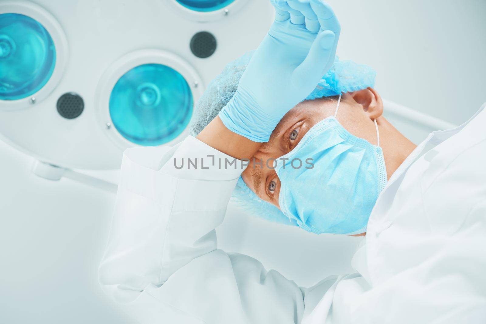 Portrait of tired young man surgeon doctor in operating room
