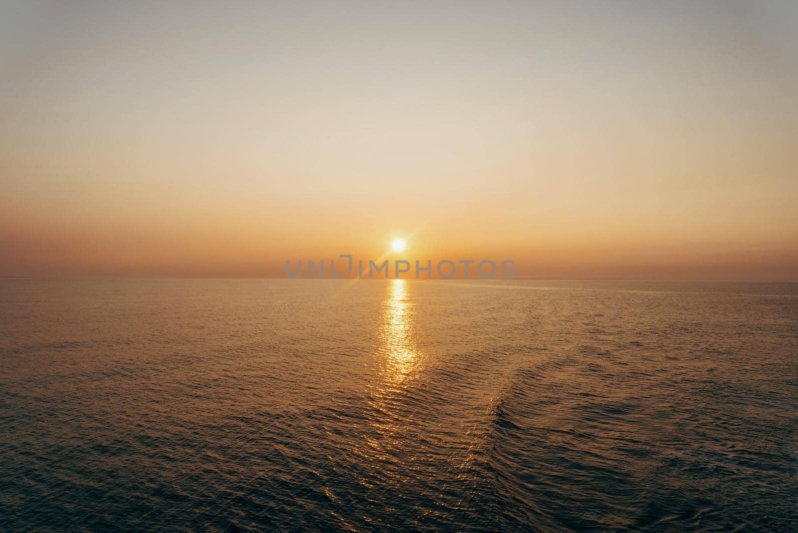Beautiful sunset over the sea with light reflection on water surface