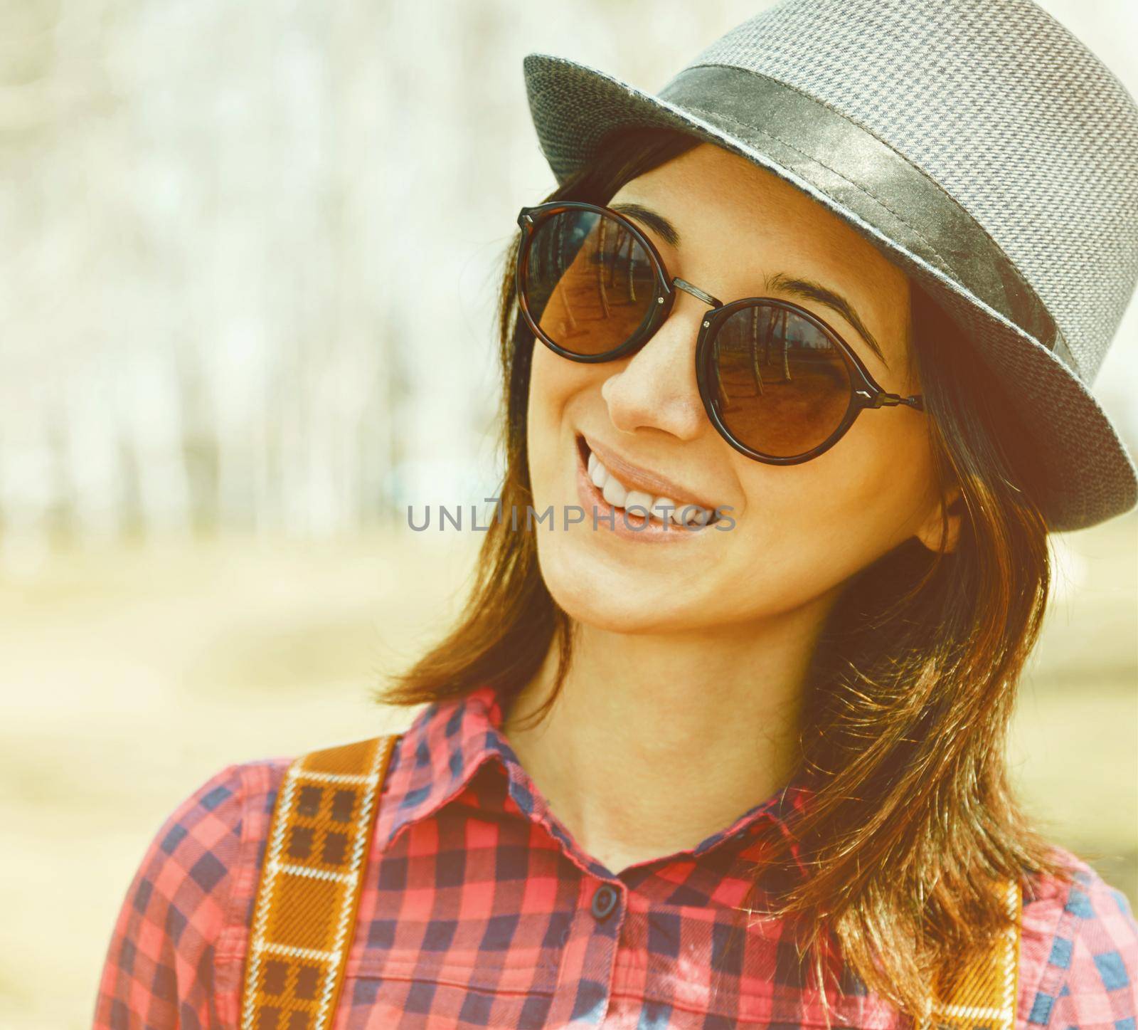 Portrait of happy hipster girl in sunglasses and hat
