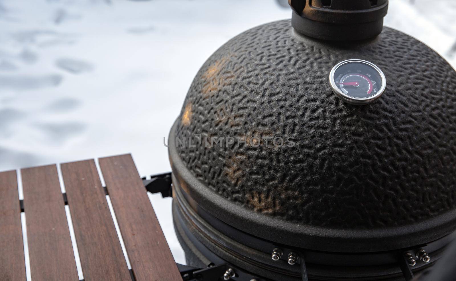 Winter bbq in the fresh white snow, Men grilling chicken wings in the winter onn grill close up