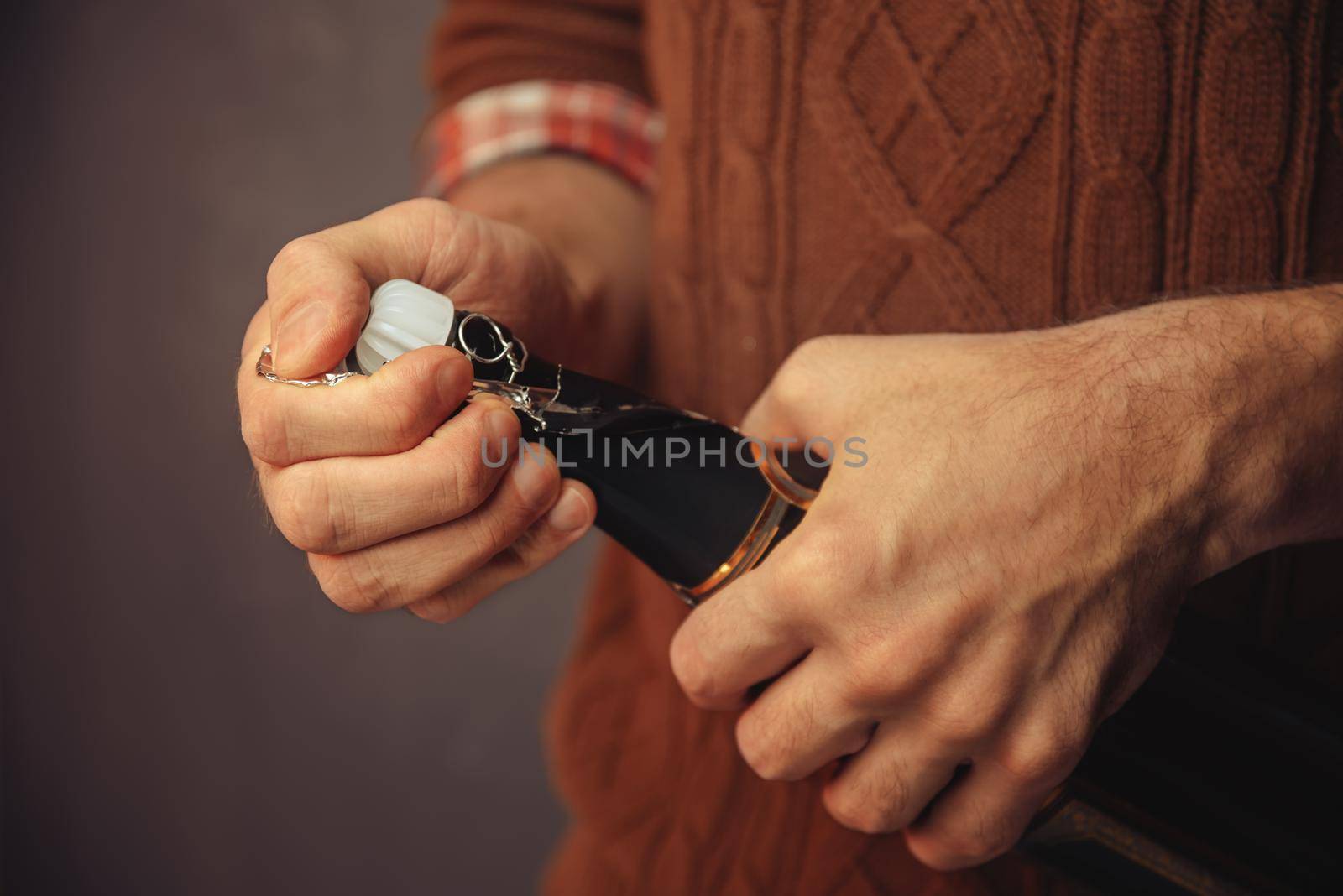 Man is opening the champagne, close-up, vintage style