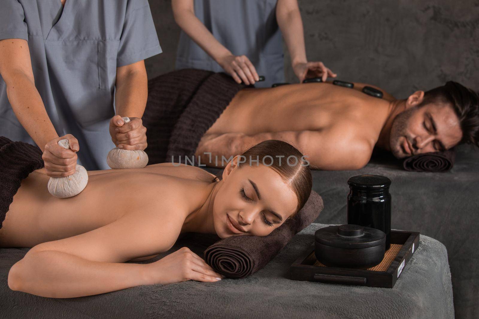 An attractive young couple lying on massage beds at a spa