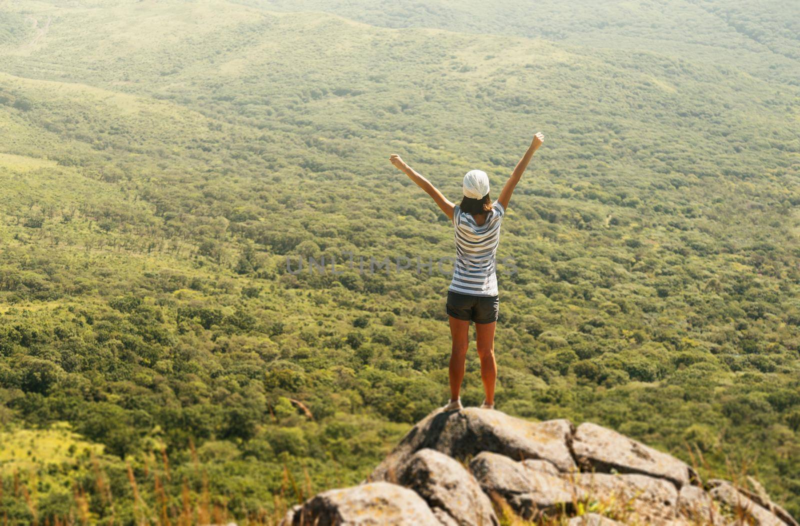 Freedom hiker woman in nature on mountain with raised arms enjoying happiness in beautiful landscape