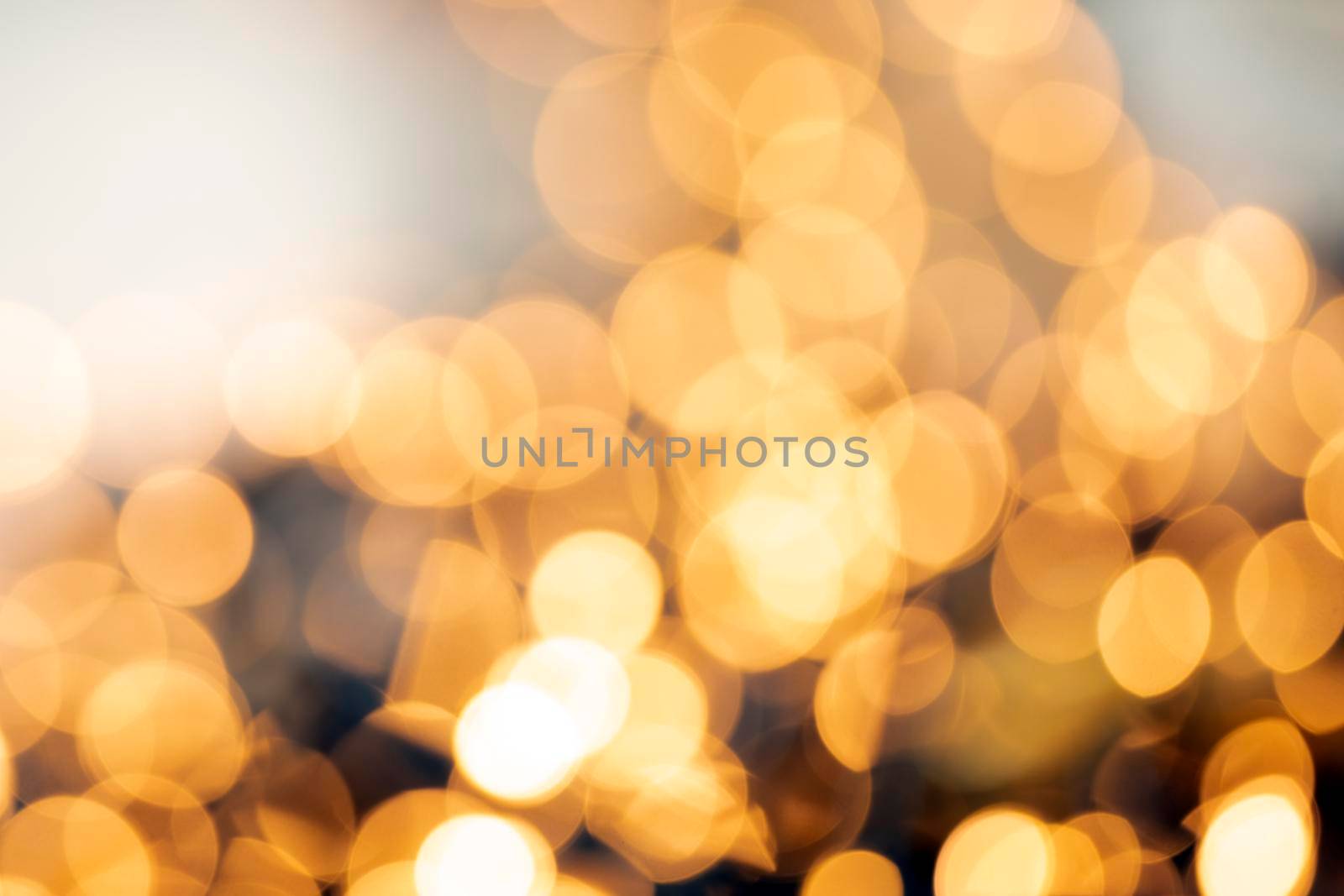 Defocused gold light abstract Christmas or Holiday background texture, sparkling yellow blurred warm tones colorful