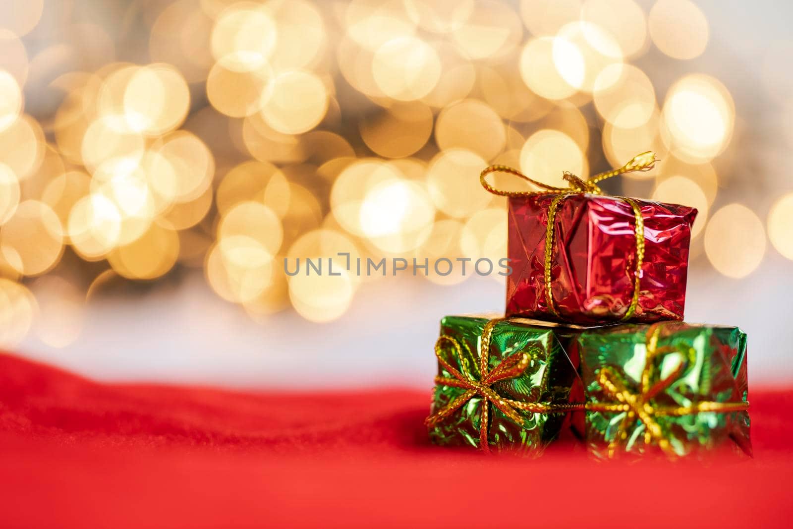christmas present red and silver baubles against bokeh lights gold shiny glitter background with copy space, space for text