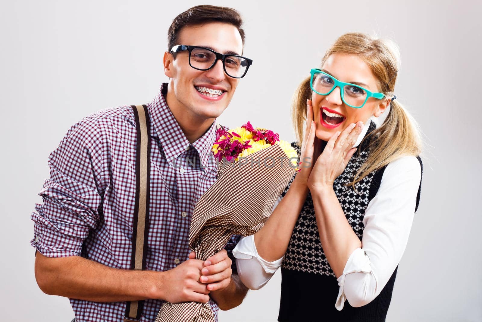 Nerdy man is giving flowers to his nerdy lady.