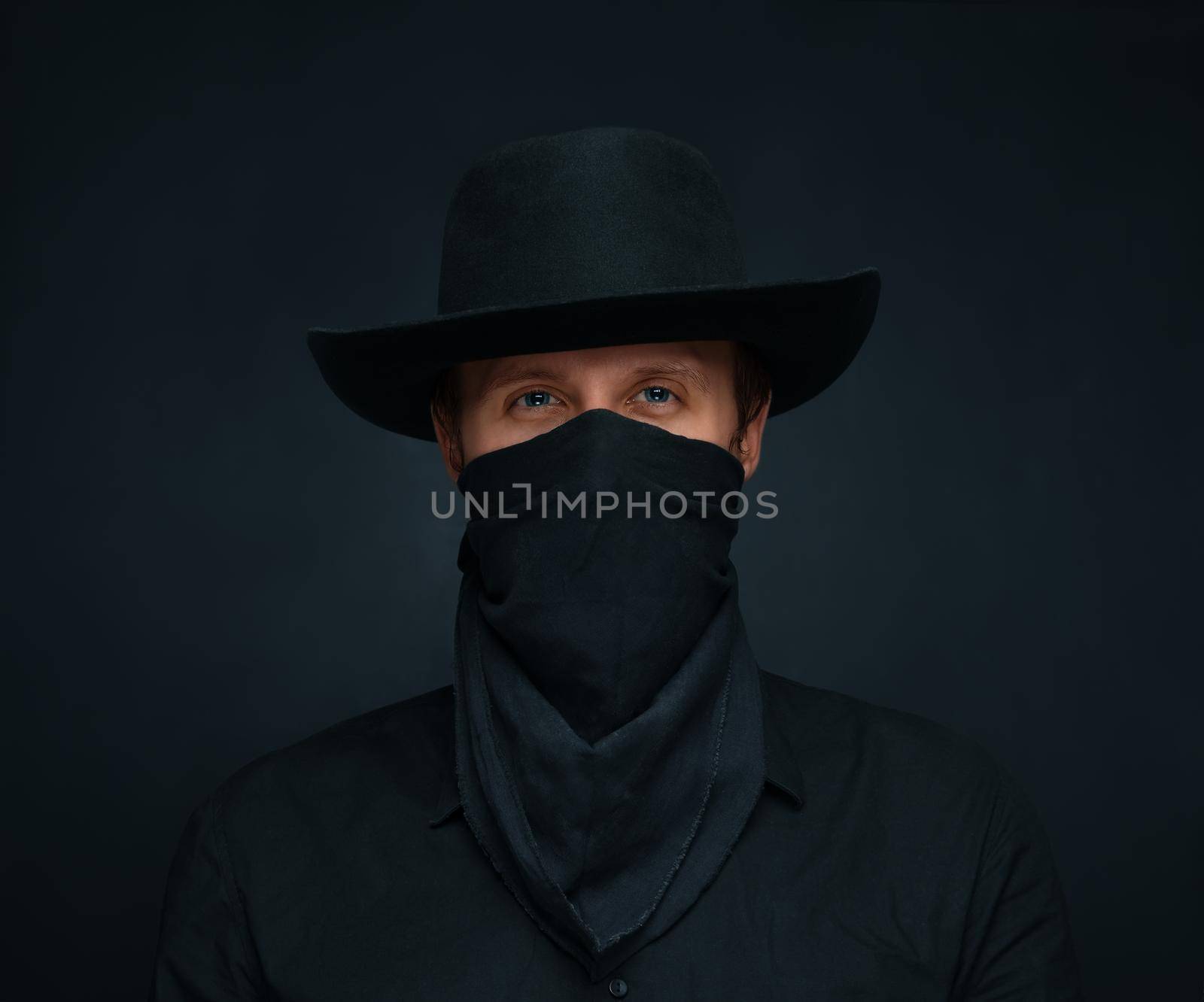 Young man dressed as a cowboy: a black hat and scarf