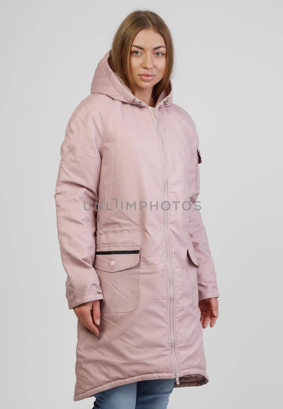 young woman in winter clothes on white background. Photo concept for advertising a down jacket by UcheaD
