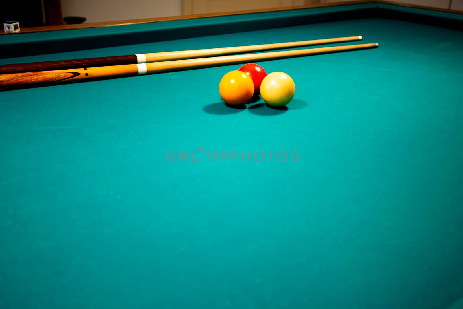 A green cloth billiards or pool table red,yellow and white ball,hobby and sport with copy space closeup
