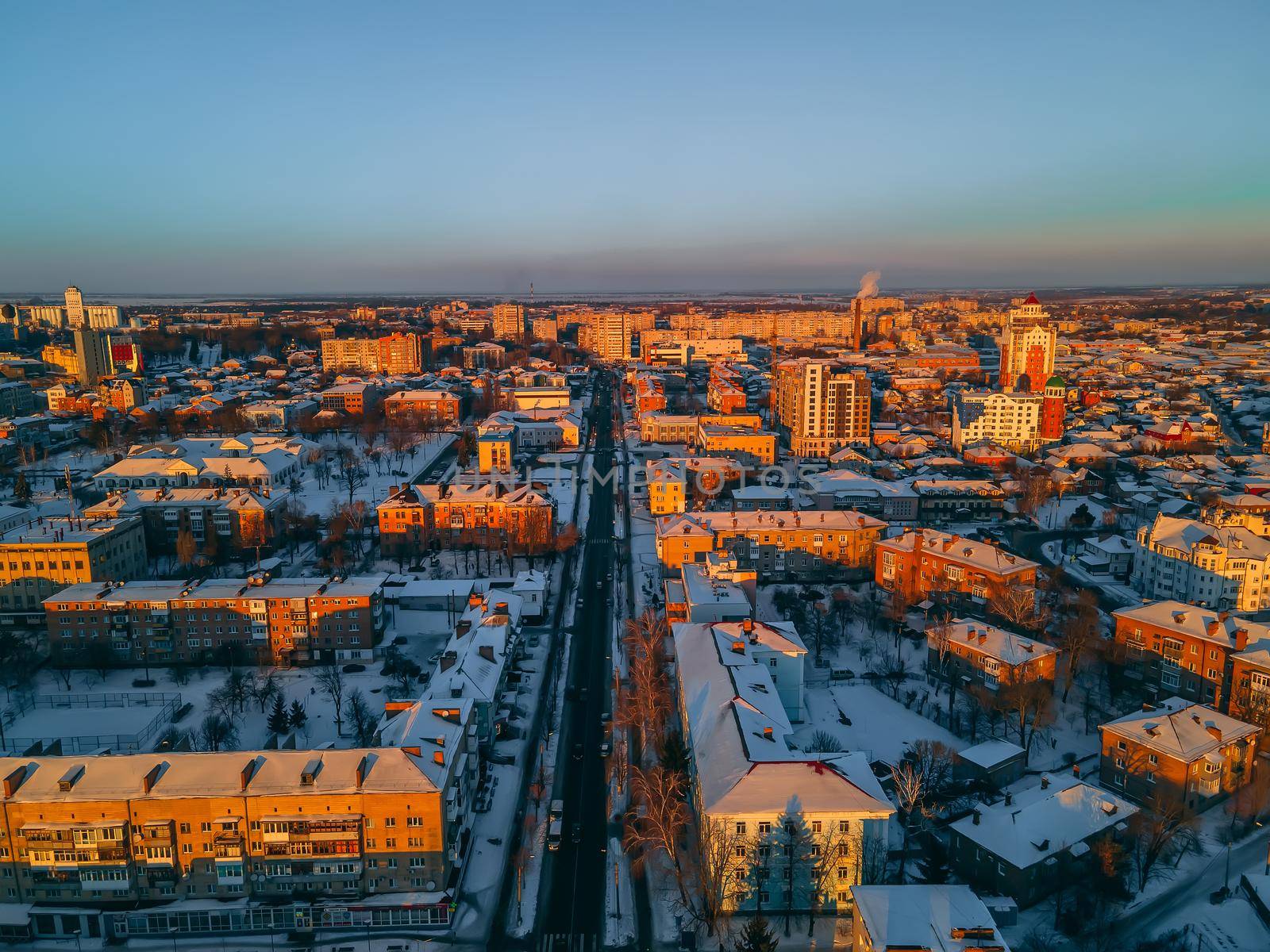 Aerial view of road in small european city with snow covered roofs at winter sunny day