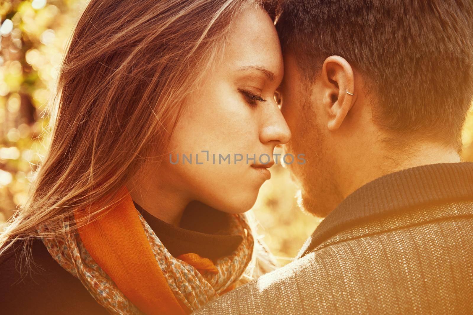 Young woman hugging man in autumn park, tender scene