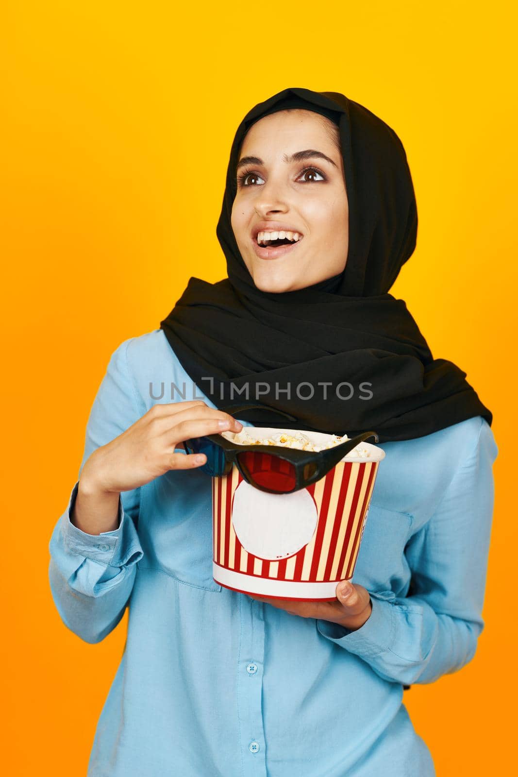 woman in black hijab with popcorn hands studio lifestyle by Vichizh