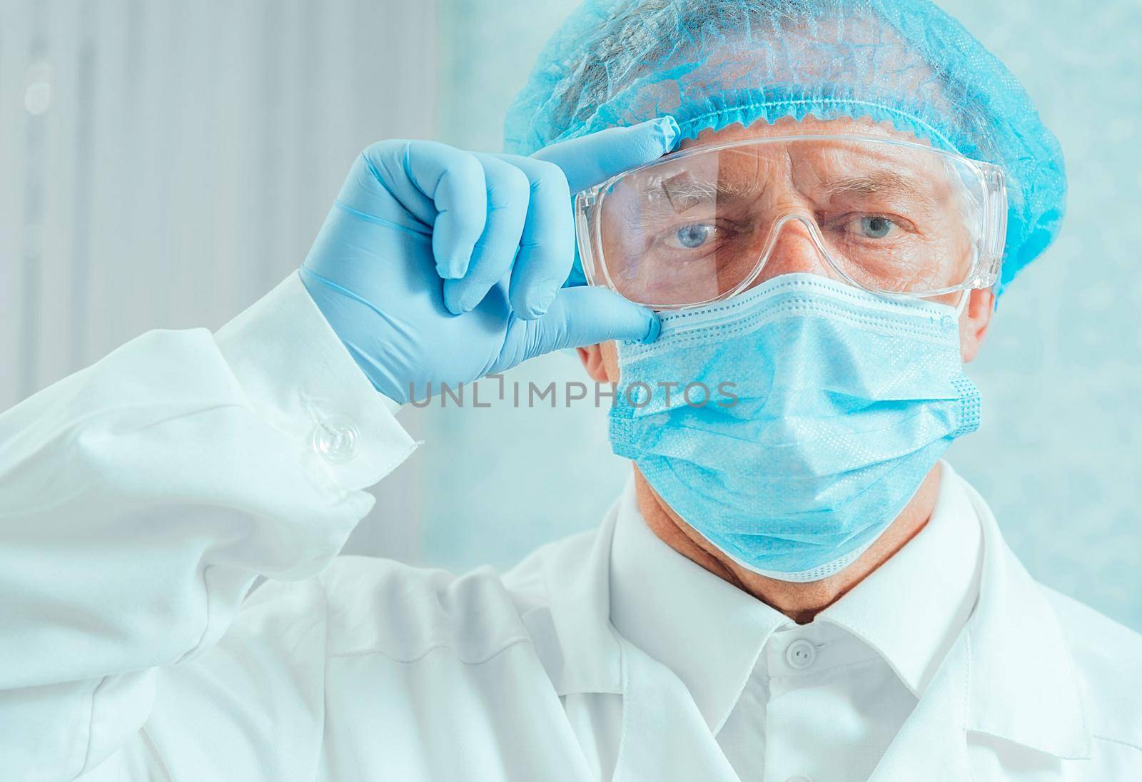 Portrait of senior man surgeon in protective uniform in hospital