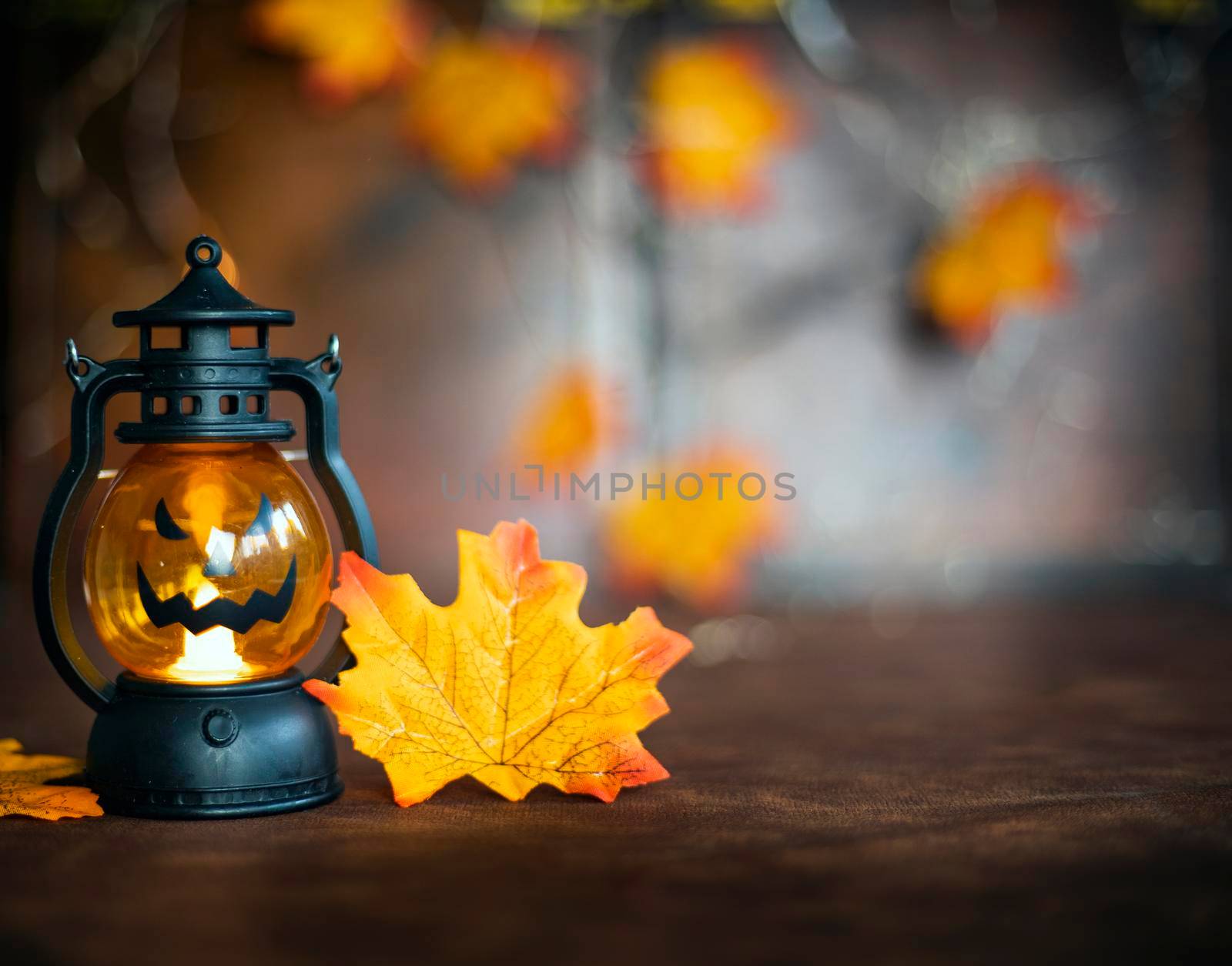 Halloween pumpkin on Autumn leaves and Jack o lantern on brown wooden background texture, Halloween,Fall and October concept copy space