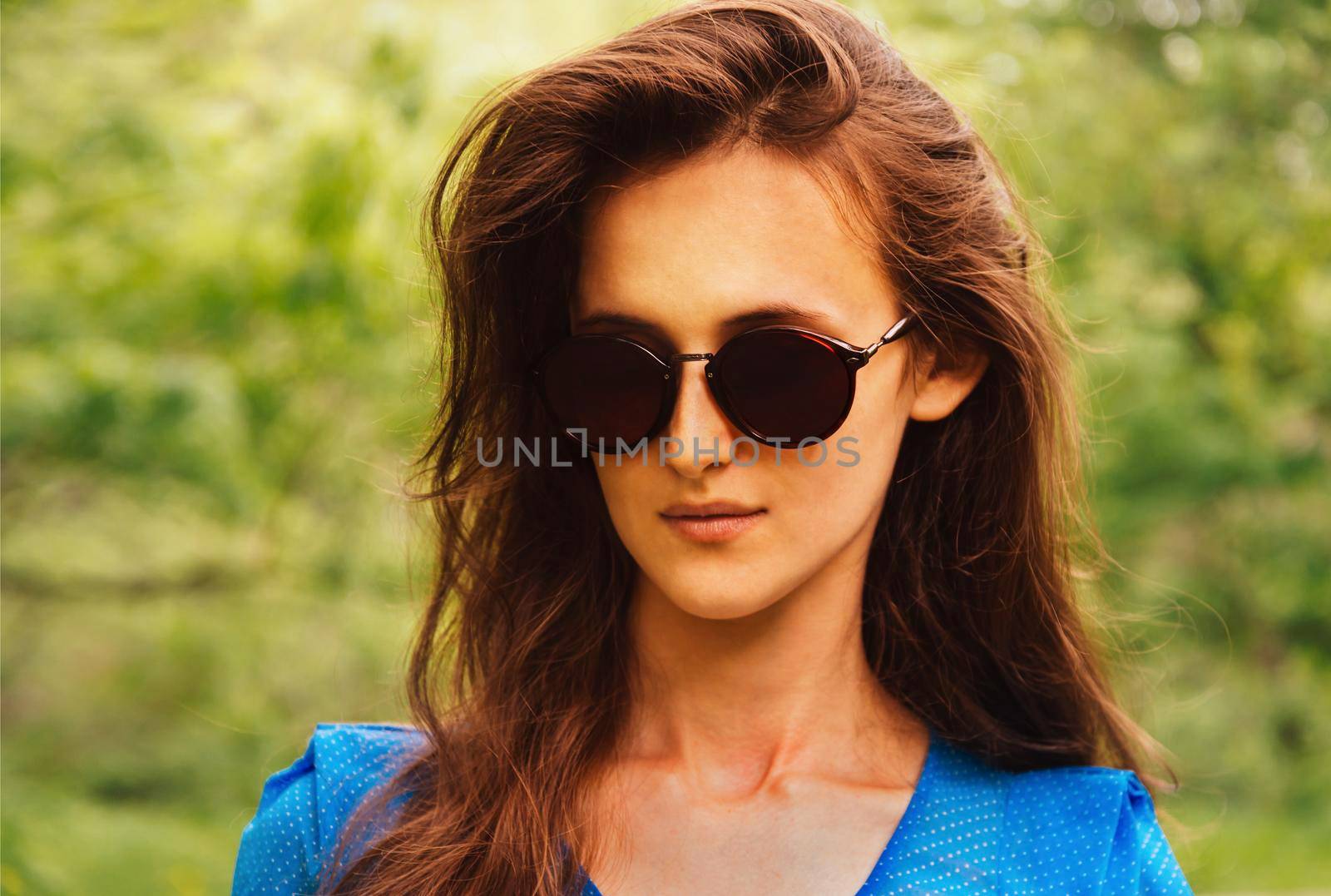 Portrait of fashionable attractive brunette woman with long hair in sunglasses outdoor
