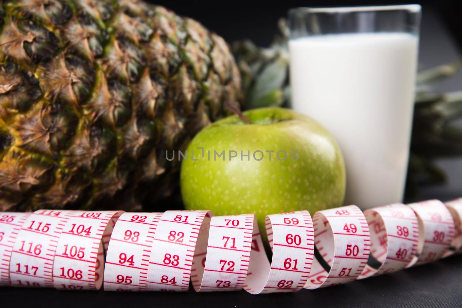 Fruits and glass of kefir with a measuring tape, close-up