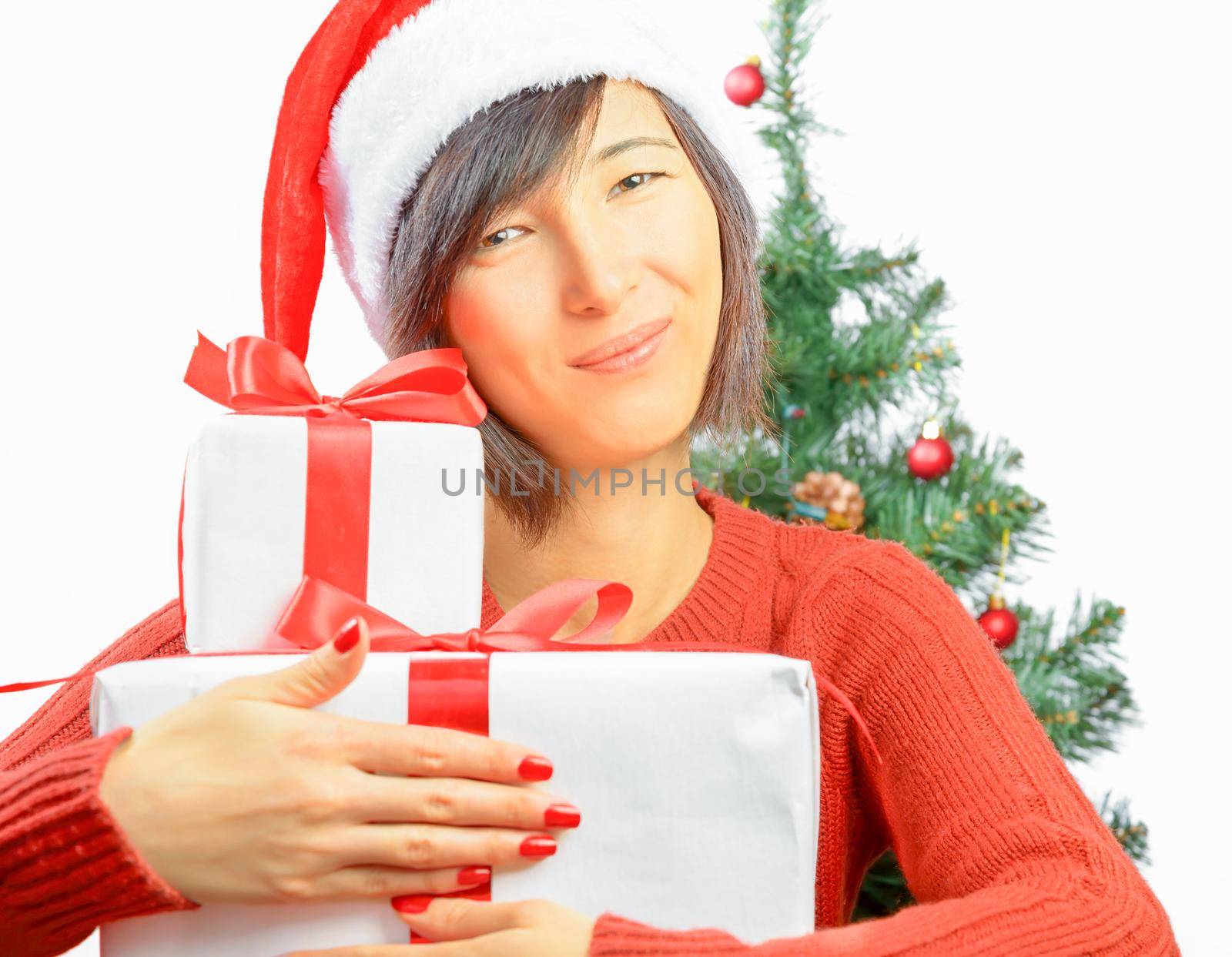 Young woman in santa hat is smiling and hugging gift box
