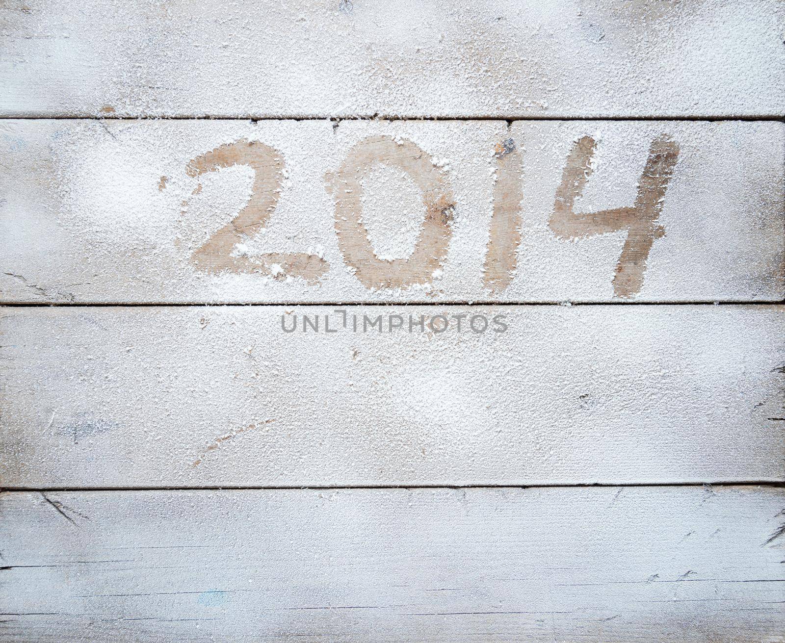 2014 written in snow on a wooden table