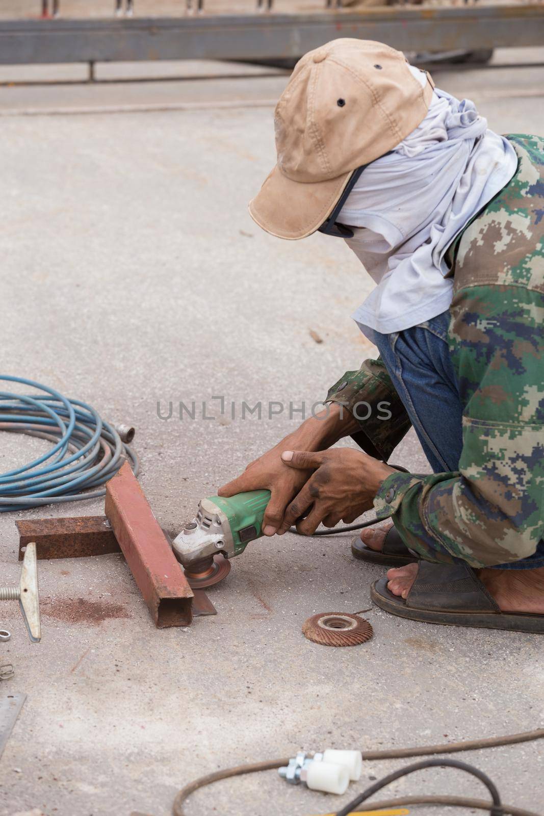 worker using an angle grinder to grinding metal
