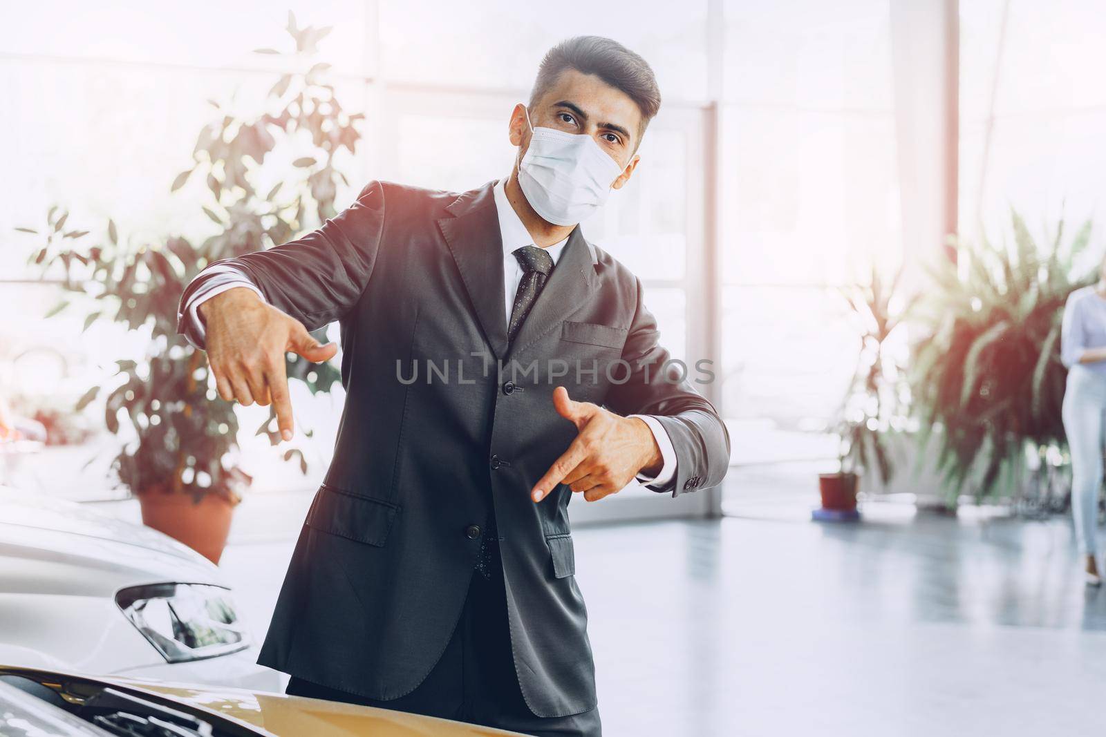 Man car dealer wearing protective medical mask on his working place, coronavirus prevention concept