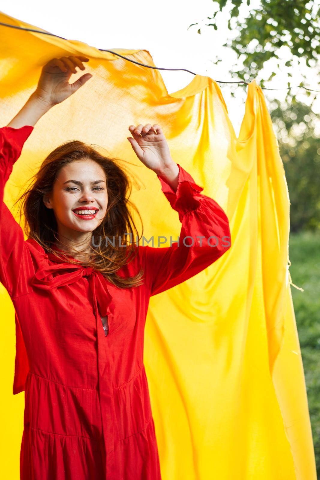 women near yellow fabric in nature in red dress fashion. High quality photo