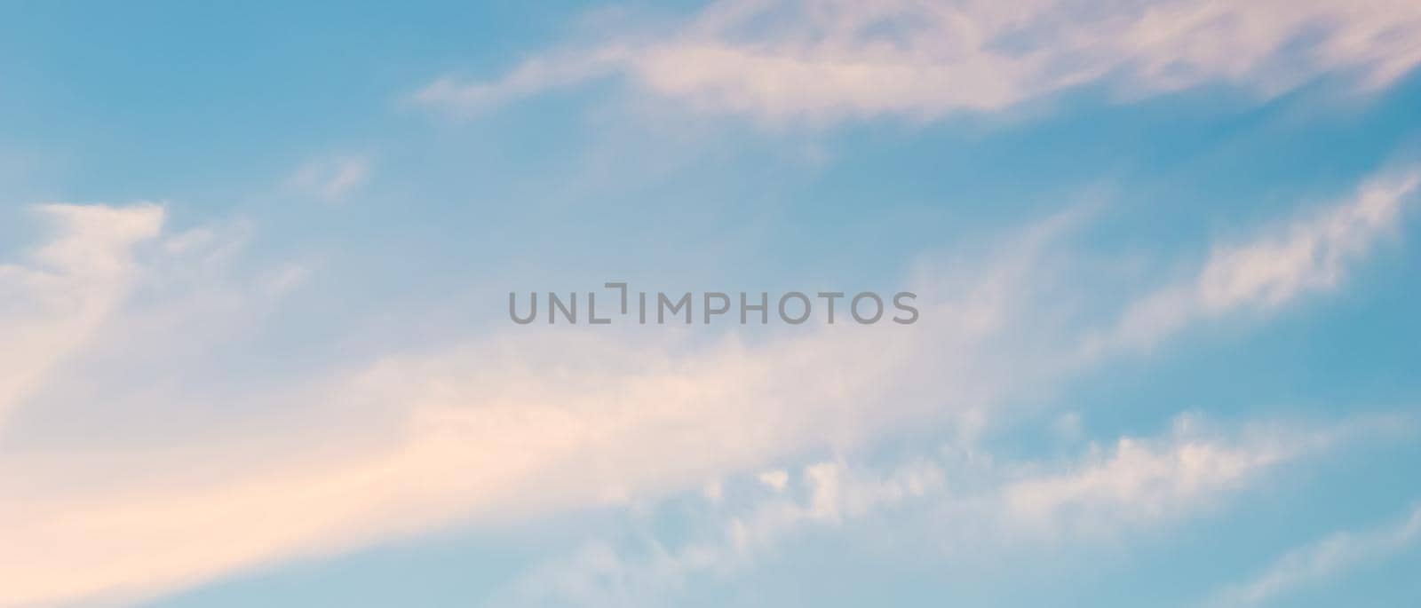 Background of blue sky with white and pink clouds in sunset