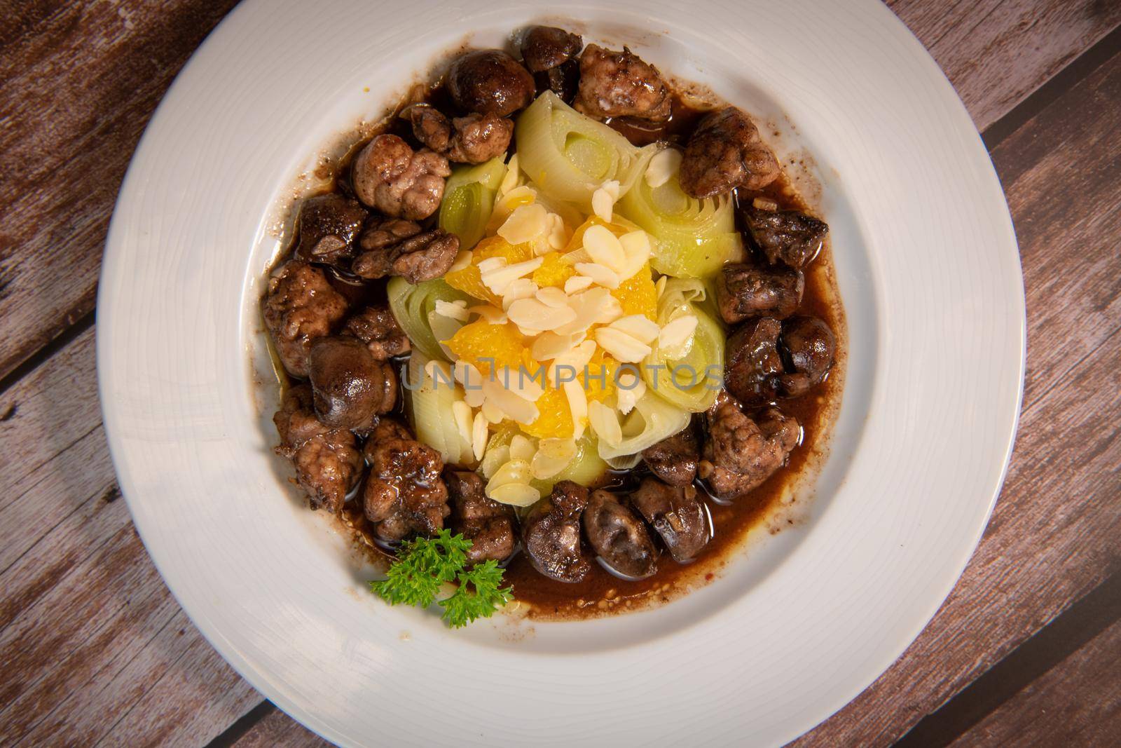 Recipe of sweetbread and lamb kidney with cocoa, leek whistles with almonds and oranges. High quality photo