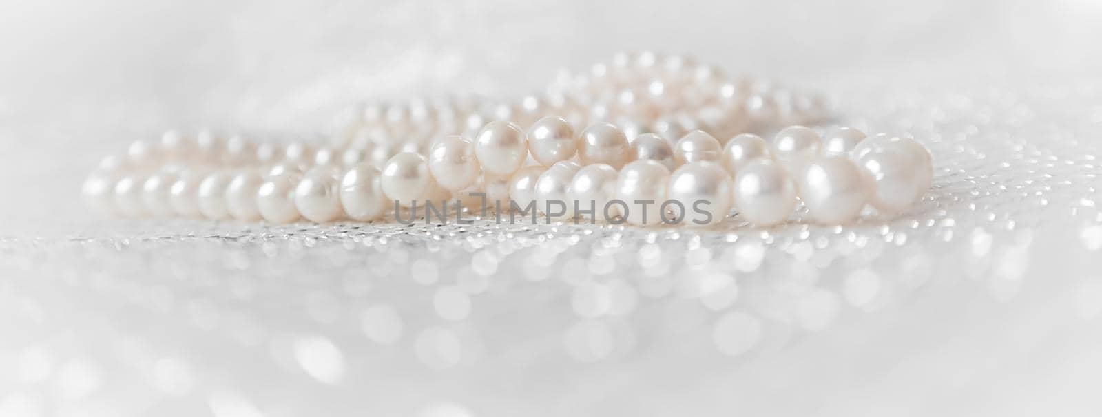 Nature white pearl beads on sparkling background.