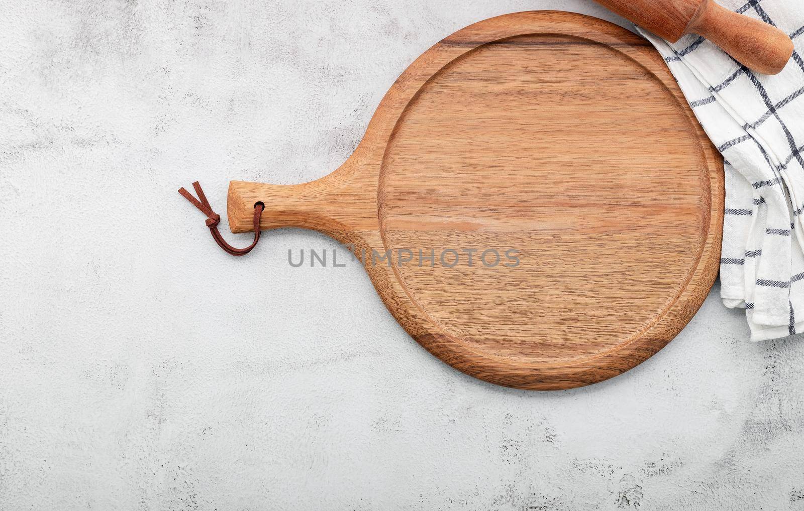 Empty wooden pizza platter set up on white concrete. Pizza board on white concrete background flat lay and copy space. by kerdkanno