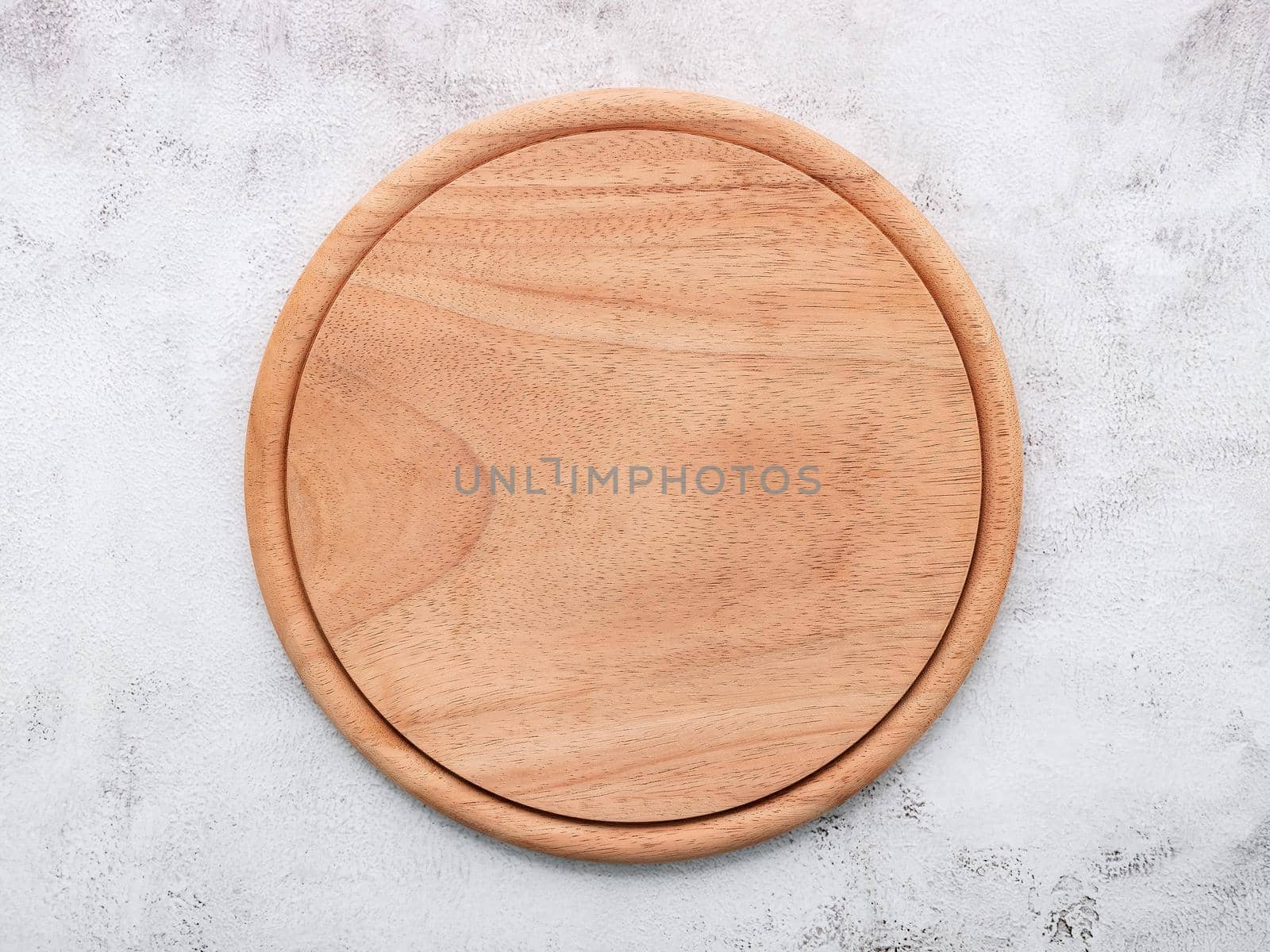 Empty wooden pizza platter set up on white concrete. Pizza board on white concrete background flat lay and copy space. by kerdkanno