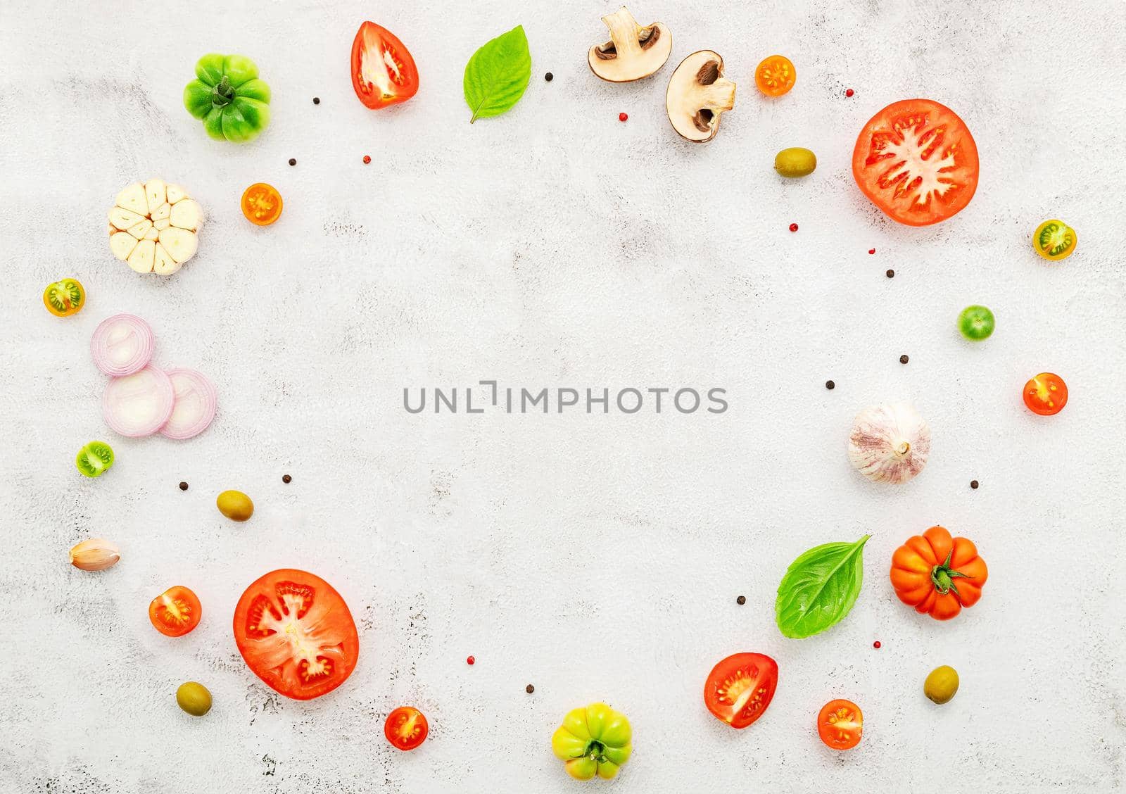 The ingredients for homemade pizza set up on white concrete background.