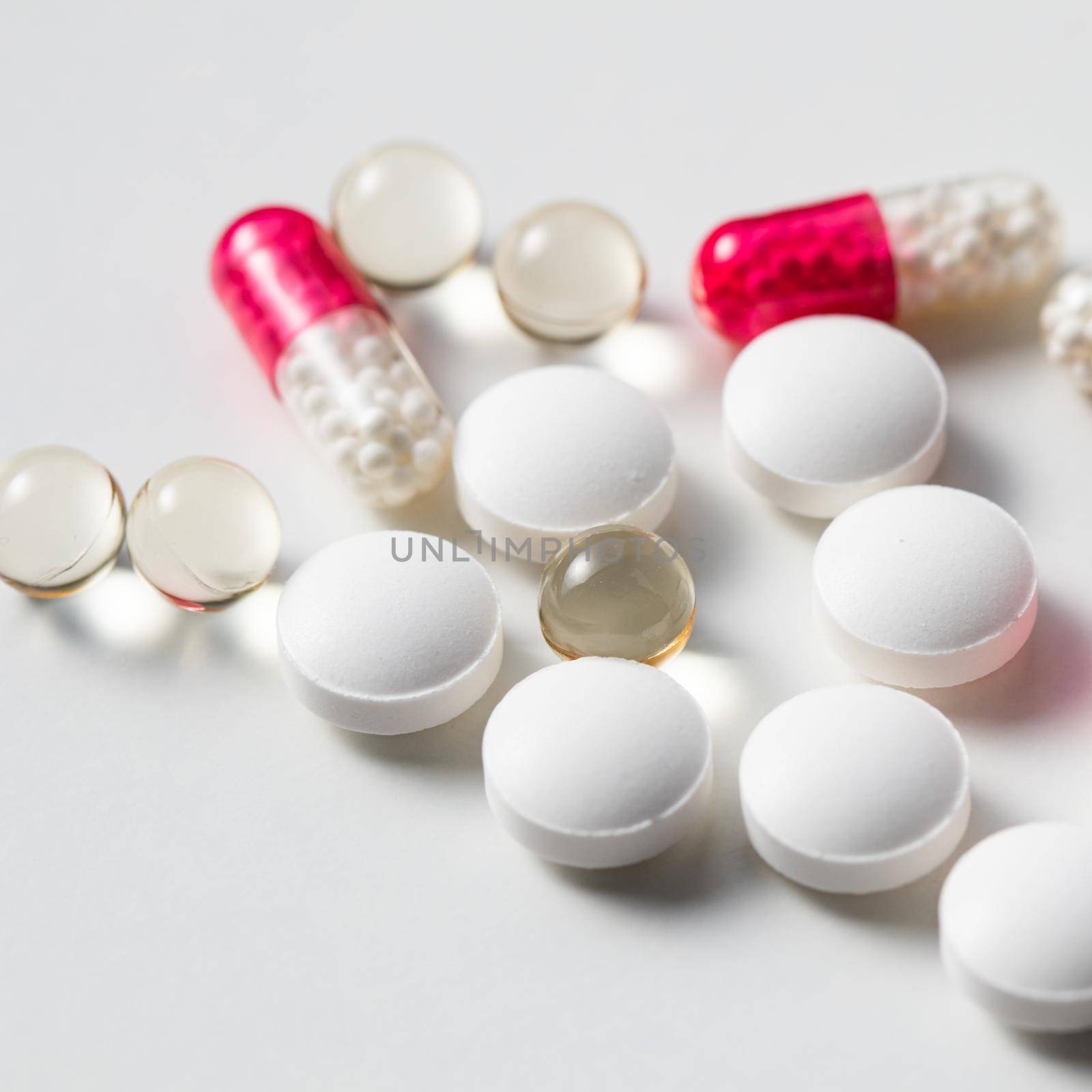 Red capsules and pills on a white background. Health care, medical, pharmacy and illness concept