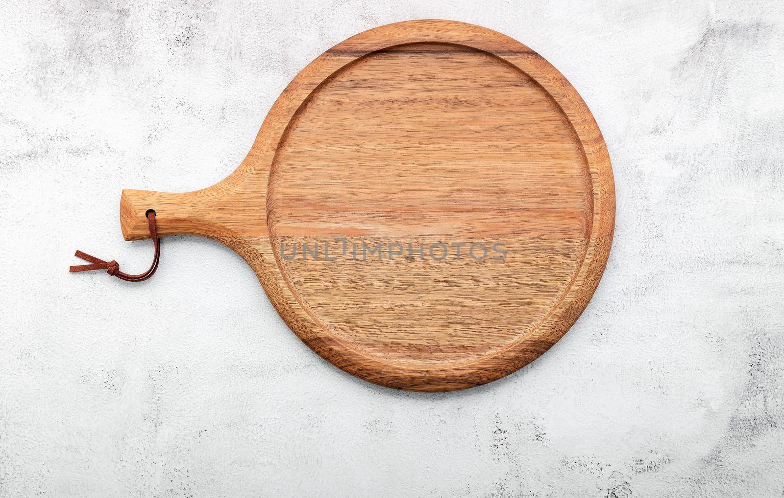 Empty wooden pizza platter set up on white concrete. Pizza board on white concrete background flat lay and copy space. by kerdkanno