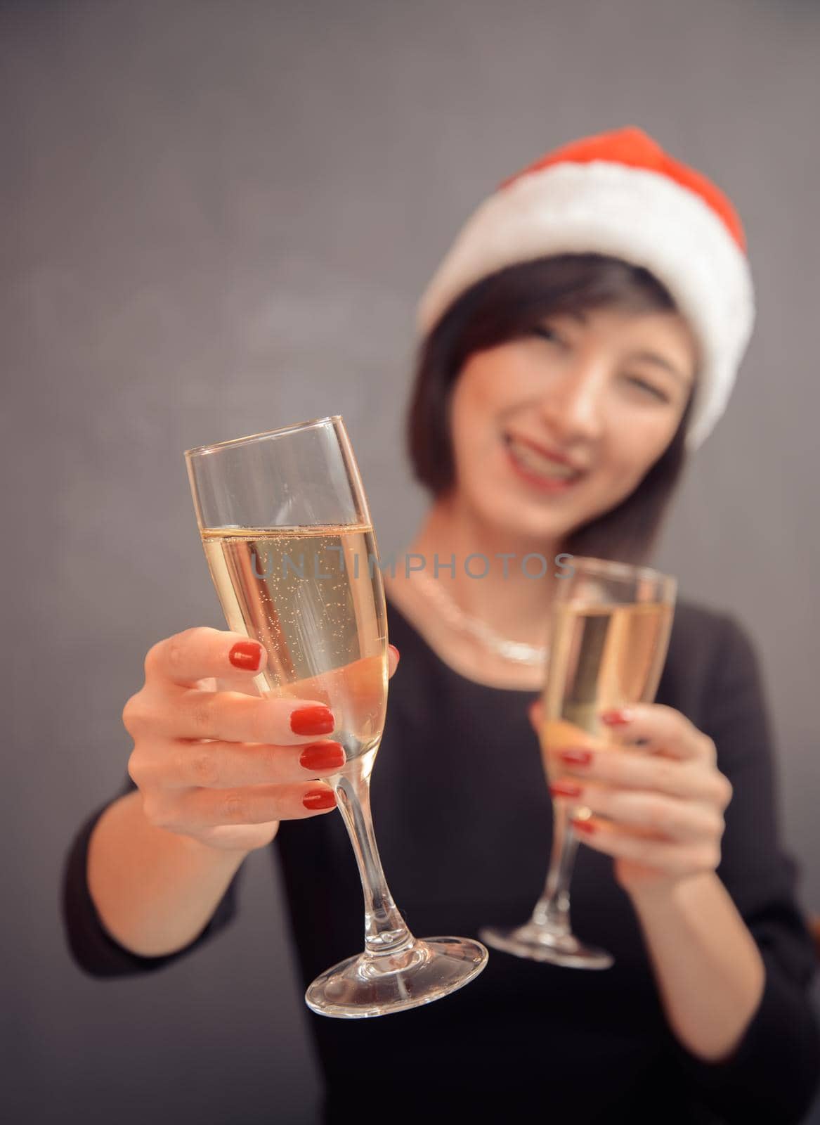 Young happy woman is giving glass with champagne