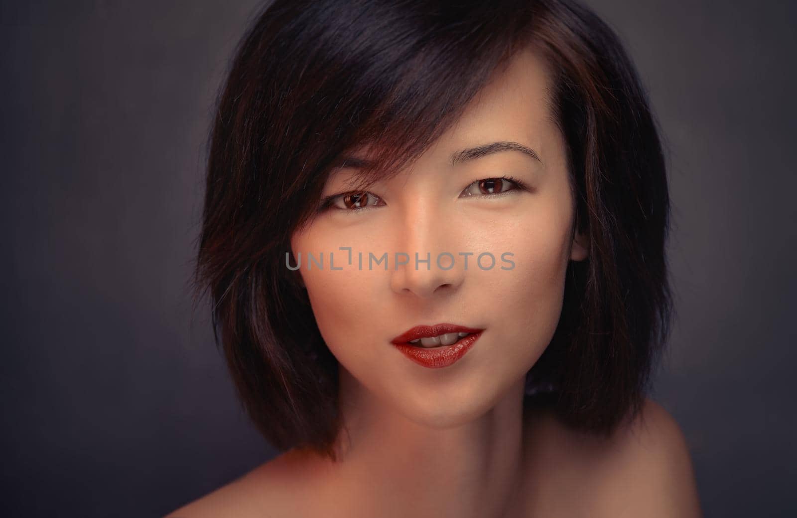 Portrait of a beautiful brunette woman on a gray background