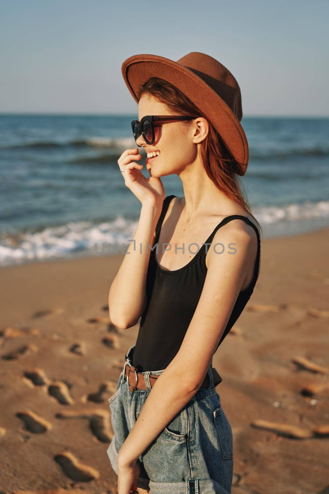 pretty woman in hat and sunglasses on the beach walk sun. High quality photo