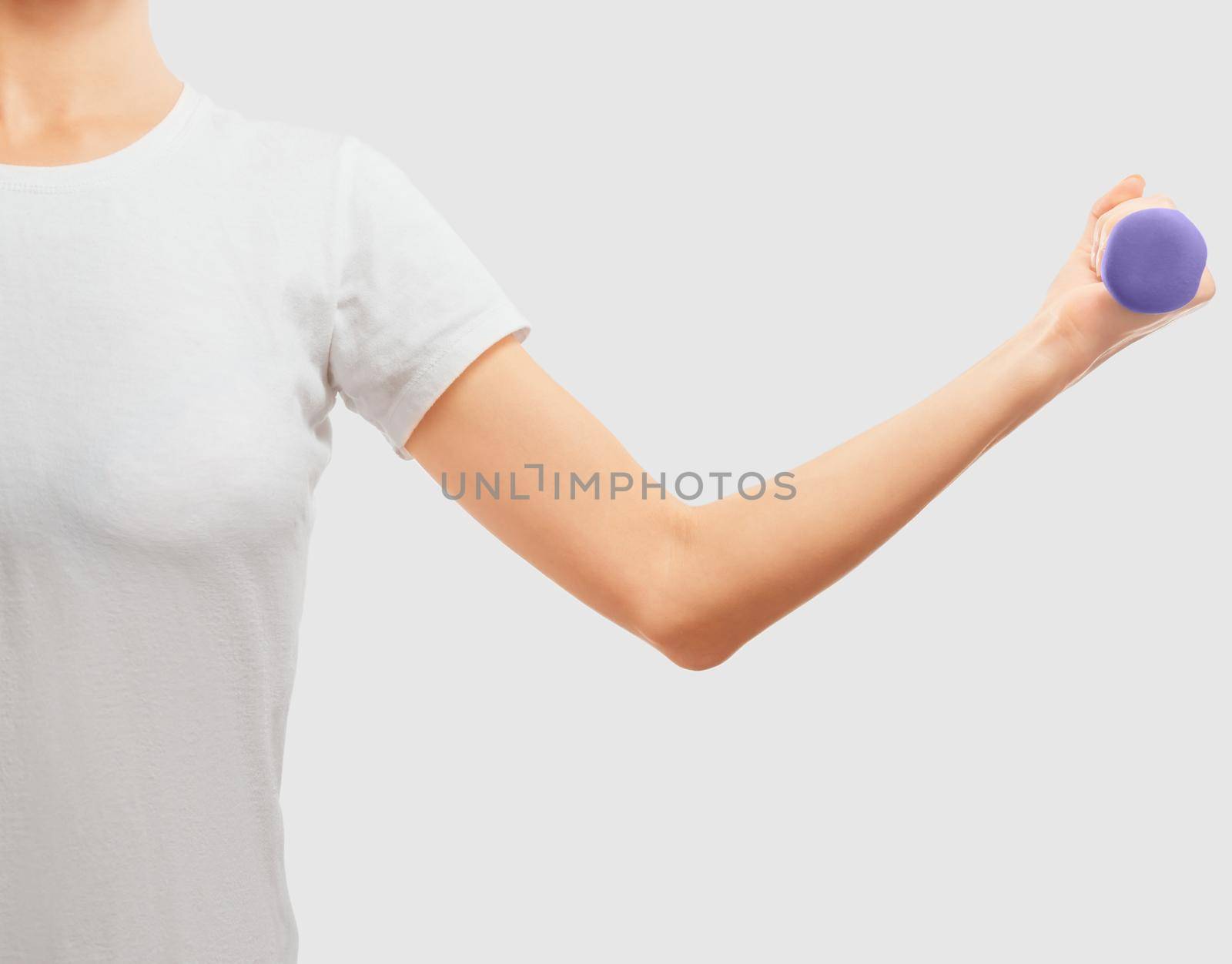 Unrecognizable woman holds a dumbbell, space for text