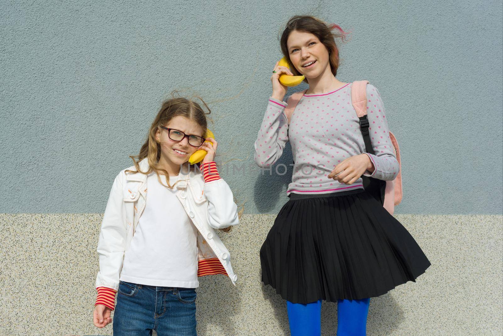 Girls teenager and child playing talking on abstract phone banana by VH-studio