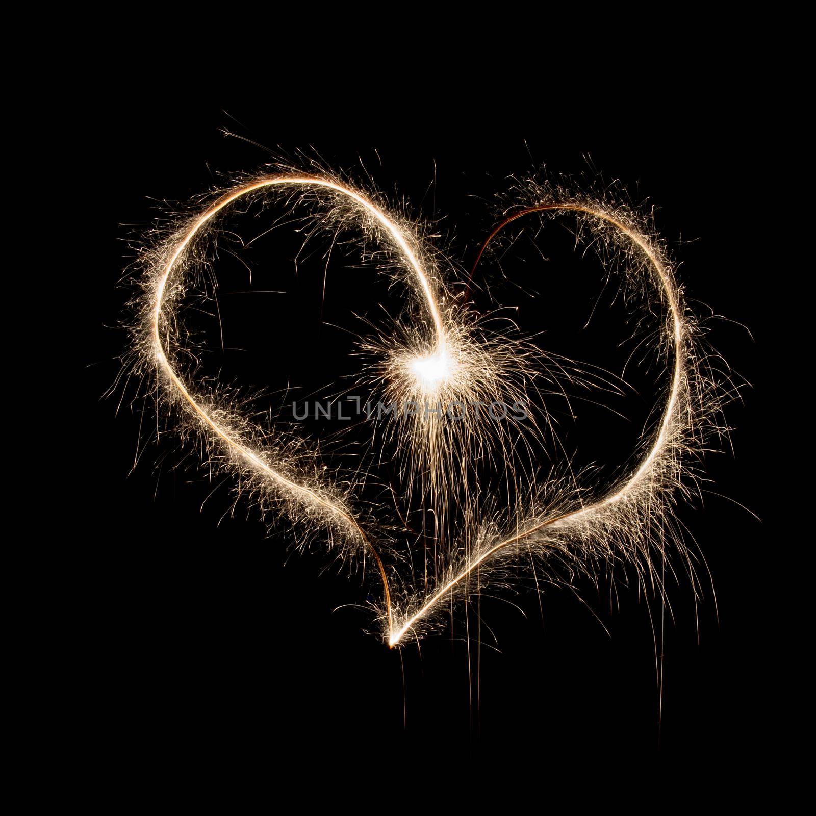 Heart shape made of sparkles on black background on holiday